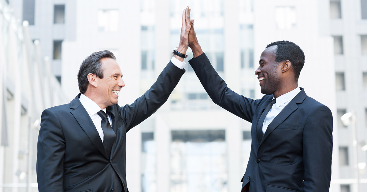 Business winners. Two cheerful business men clapping each other